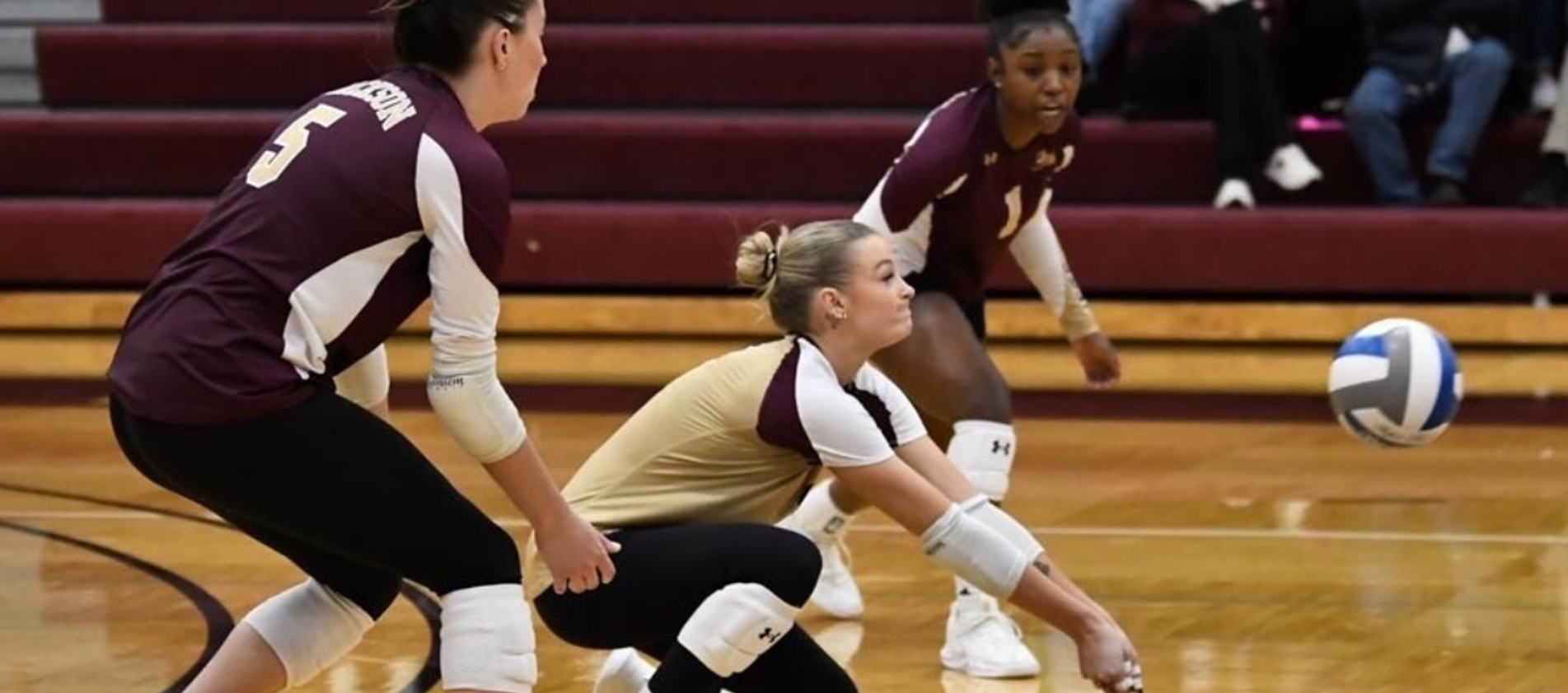 three girls from JC volleyball team hitting the ball